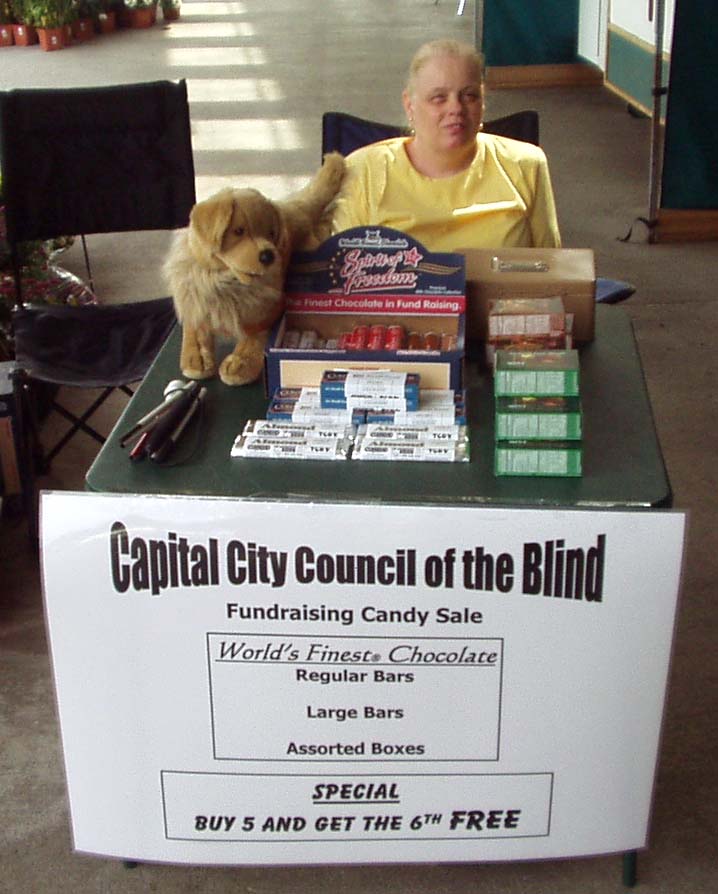 Anna sitting at a card table selling candy.